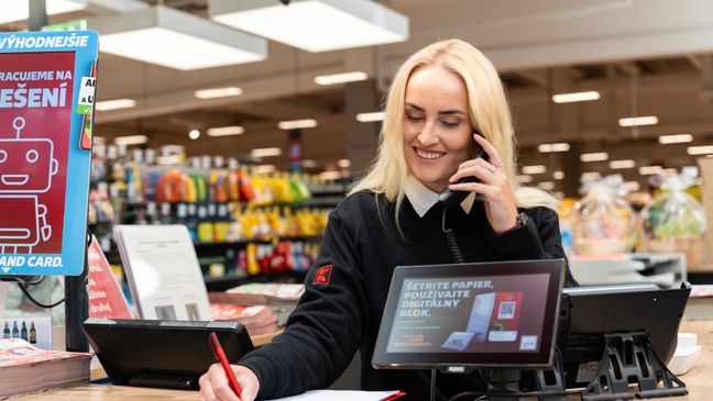 Trainee pri telefonickom rozhovore na info pulte v predajni