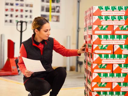 Im Lager einer Kaufland-Filiale: Verkaufsmitarbeiterin überprüft eine Paletten-Ladung Tomaten-Tetrapaks.
