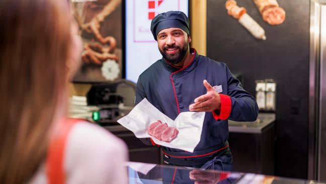 An der Bedientheke einer Kaufland-Filiale: Mitarbeiter in der Fleisch- und Wurstabteilung präsentiert der Kundin 4 Scheiben des gewünschten Fleisches.
