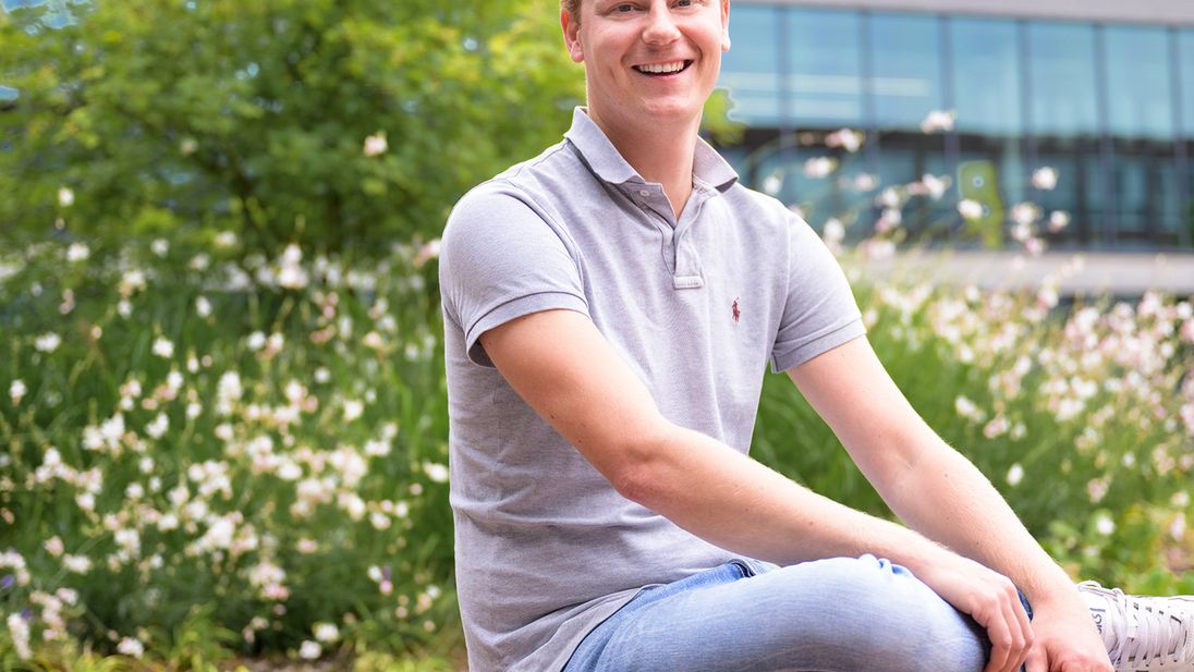 IT collega Stefan zit op bankje in de Lidl campus tuin