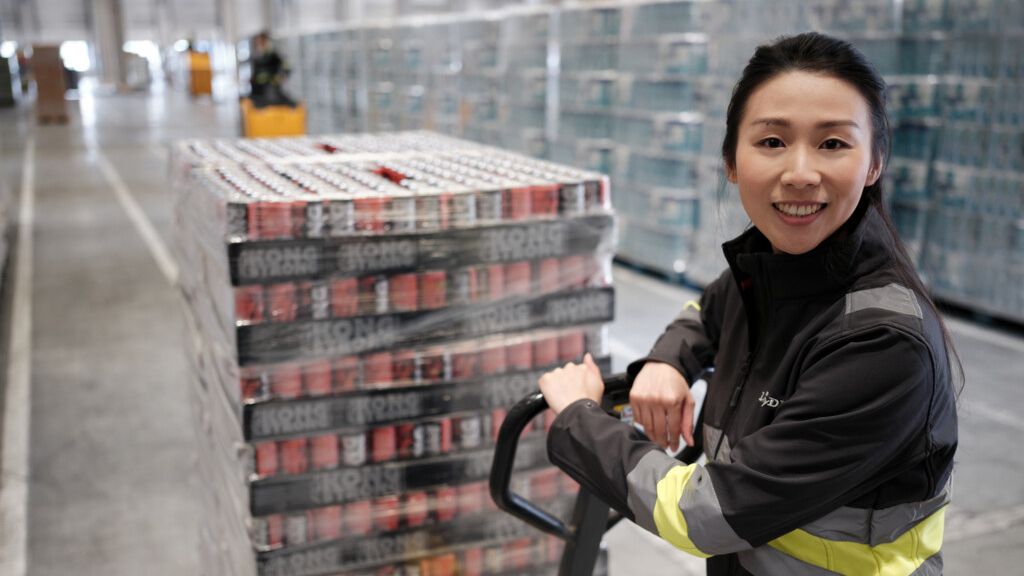 Kommissioniererin mit Palette im Logistiklager