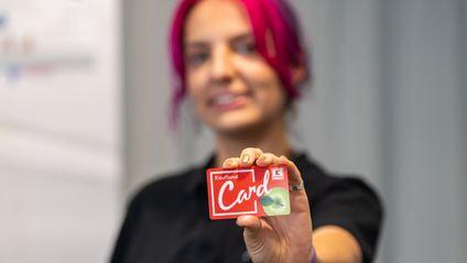 Pracovníčka marketingu drží v ruke vernostnú kartu Kaufland Card