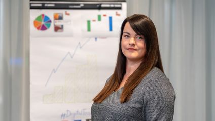 marketingová špecialistka v office pri nástenke s grafom