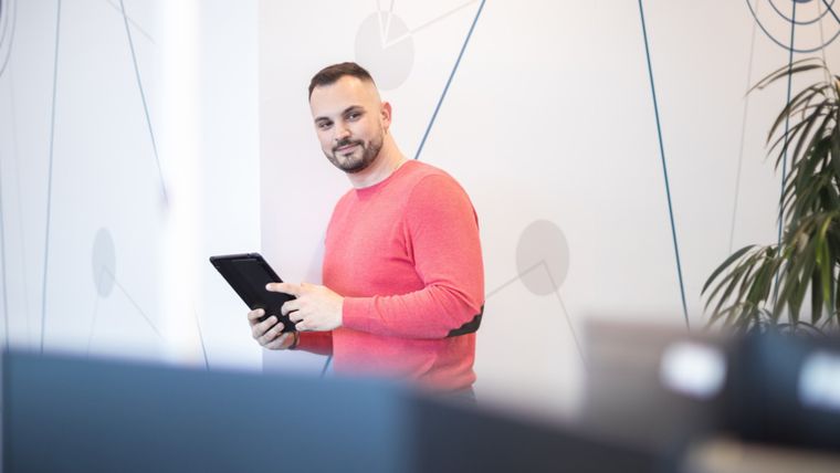 zamestnanec drží v ruke tablet