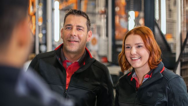 Zwei Logistik-Mitarbeiter von Kaufland unterhalten sich mit einem Kollegen.