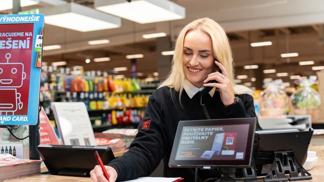 Trainee pri telefonickom rozhovore na info pulte v predajni