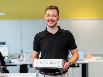 Odborný asistent drží darček pre svoje novonarodené dieťa