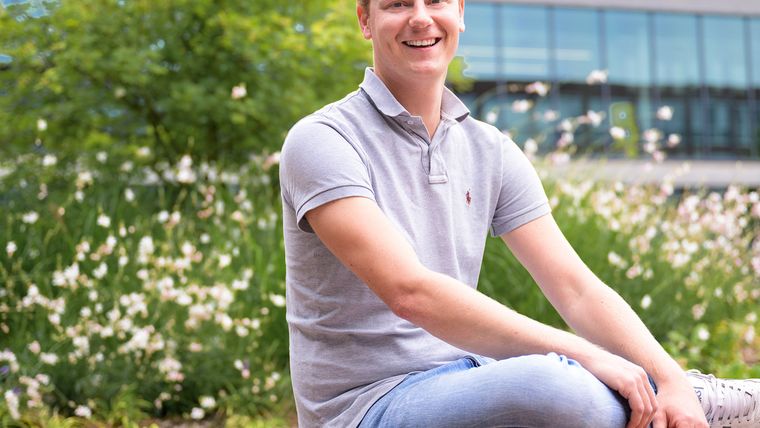 IT collega Stefan zit op bankje in de Lidl campus tuin