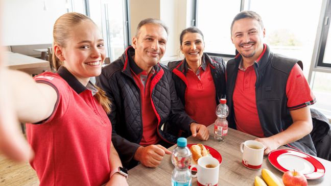 Selfie-Gruppenbild vom Kaufland-Logistiksteam im Pausenraum.