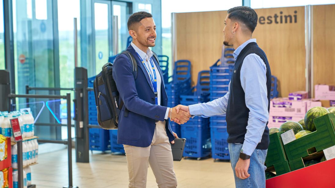 area manager e apprendista assistant store manager si stringono la mano