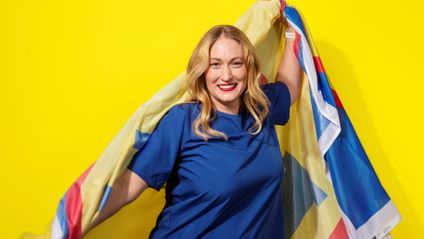 Nainen hymyilee Lidl-viitta harteillaan