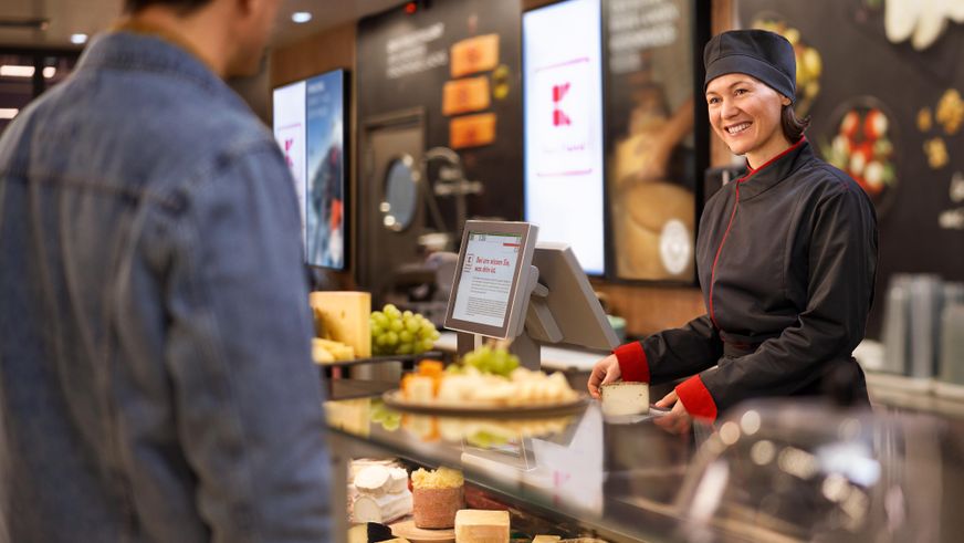 Kaufland-Bedientheke: Eine Verkaufsmitarbeiterin am Käsetresen im Gespräch mit dem Kunden.