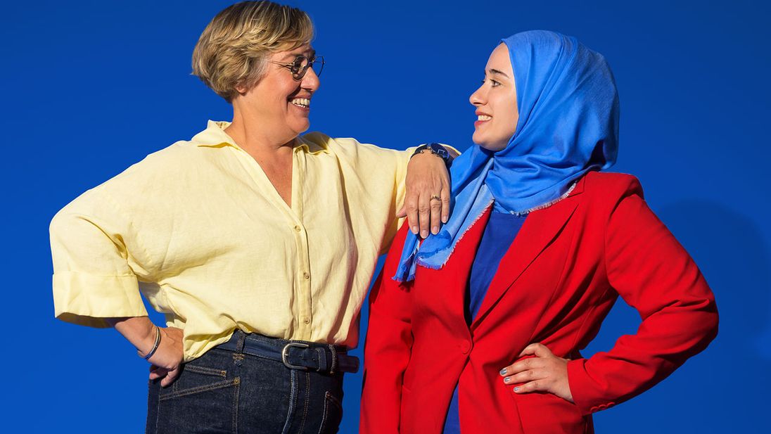 Twee Lidl medewerkers lachen naar elkaar