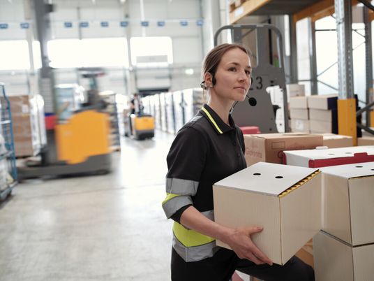 Lagermitarbeiterin verräumt Kisten
