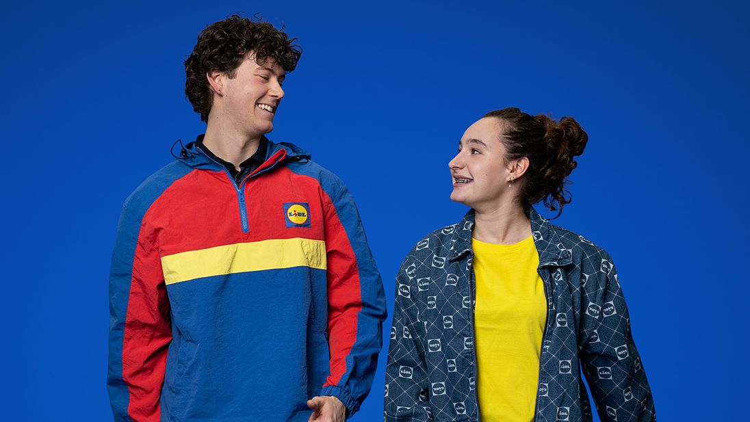Twee enthousiaste Lidl hulpkrachten gekleed in Lidl merchandise