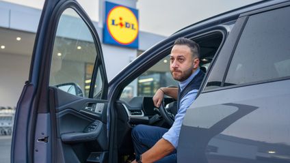 Der Filialleiter sitzt im Auto.