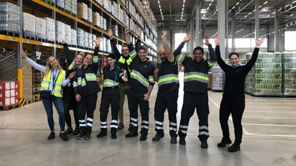 Työntekijät tuulettavat iloisesti jakelukeskuksessa