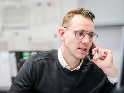 Hausleiter telefoniert im Büro.