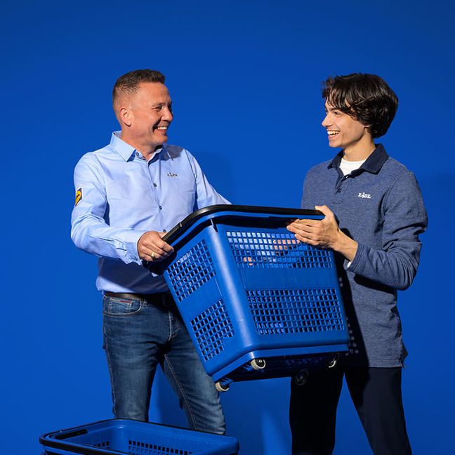 Supermarktmanager werk samen hulpkracht bij de kassamandjes