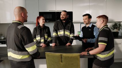 Lagermitarbeiter mit Teamleiter beim Teammeeting in Betriebsküche