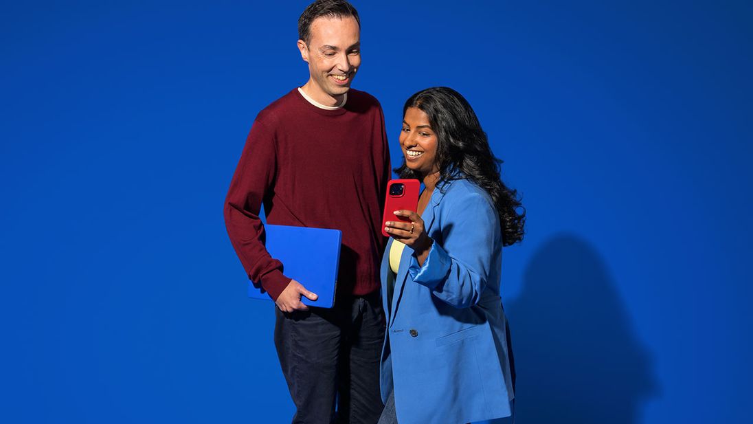Twee internal audit medewerkers kijken op smartphone bij de Lidl Campus Huizen