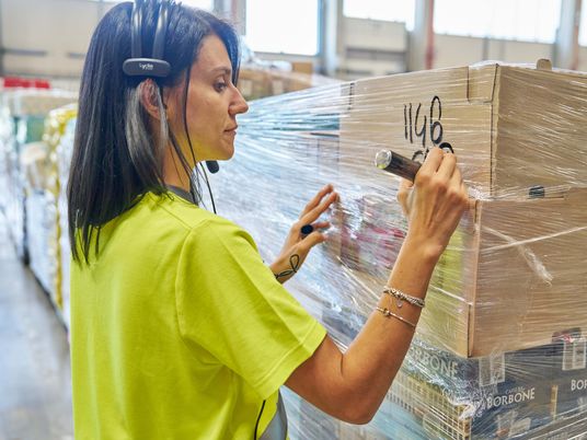 Preparatrice Merce in magazzino verifica i pallet per la spedizione