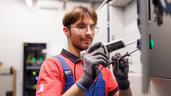 Techniker von Kaufland mit einem elektrischen Prüfgerät.