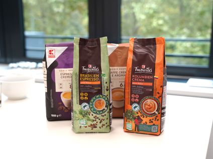 Kaffeeverpackungen der Eigenmarke K-Classic und K-Favourites stehen auf einem Tisch.
