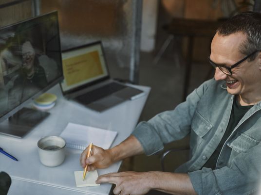 man in front of computer laughing