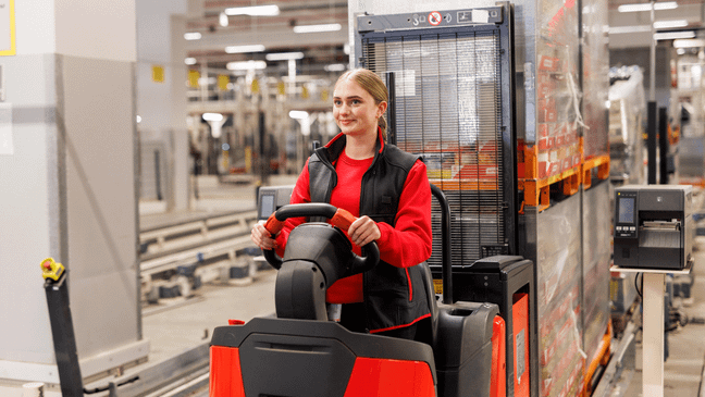 Eine Azubi bedient ein Flurförderfahrzeug im Logistik-Lager.