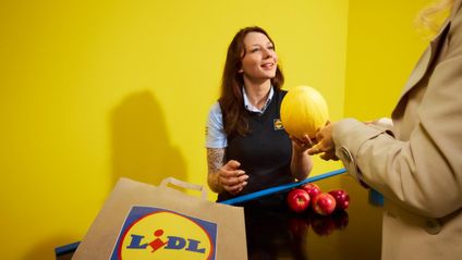 Mitarbeiterin kassiert Obst und Gemüse