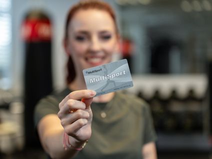Zamestnankyňa drží kartu Multisport v posilňovni.