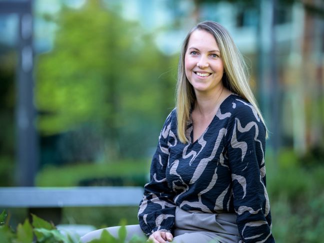 IT manager Stefanie zit in de campus tuin Huizen