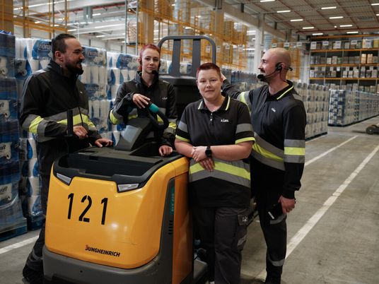 Teamversammlung der Lagermitarbeiter am Gabelstapler im Warenlager