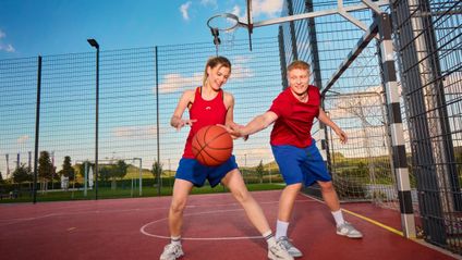 Mitarbeiter:innen spielen Basketball beim Teamevent