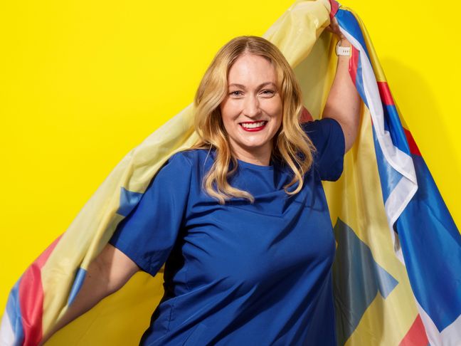 Nainen hymyilee Lidl-viitta harteillaan