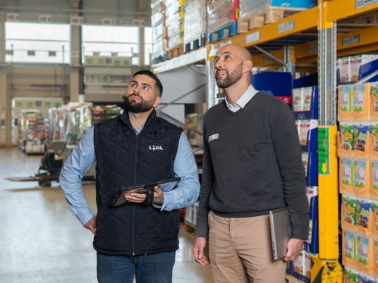 Un responsable logistique et son Directeur observe un rayon de la plateforme