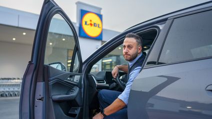 Filialleiter steigt aus Auto aus.