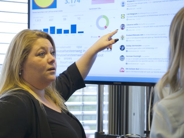 Collega's die naar een webcare scherm kijkt