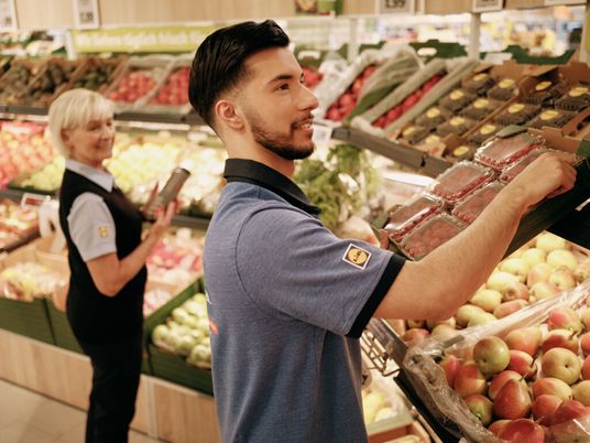 Stellvertretende Filialleiterin und Student kontrollieren Obst und Gemüse