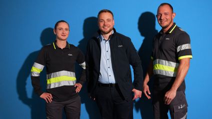 Logistik Team 3er Gruppe vor blauem Hintergrund