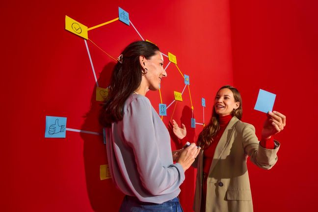 Mitarbeiterinnen vor einer Pinwand