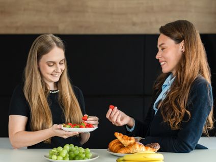 zamestnankyne v kuchynke pri raňajkách s ovocím a pečivom