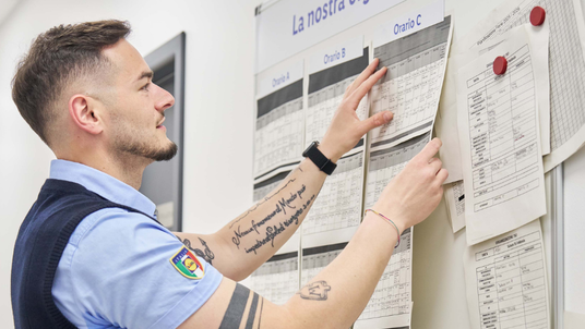 store manager guarda bacheca turni di lavoro