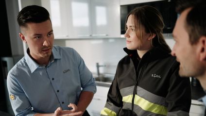 Teamgespräch der Lagermitarbeiter mit Teamleiter in Betriebsküche