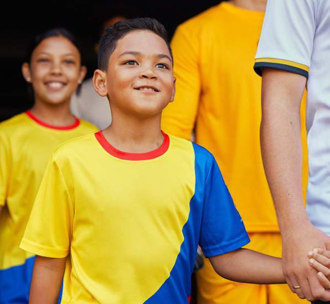 Kind läuft als Begleitung bei einem Fußballspiel mit ein